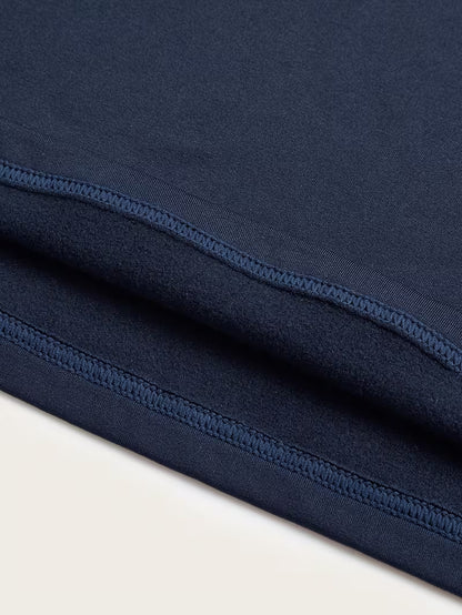 Close-up of navy blue fabric with a visible seam on a light beige background